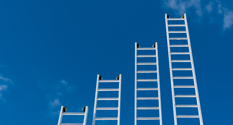 four ladders of varying lengths against a sky background