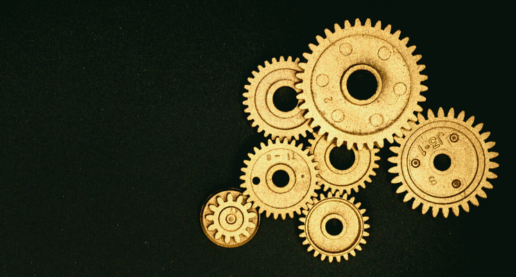 several different gold gears against a black background